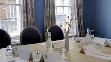 A conference room with a long table, name cards, and glassware.