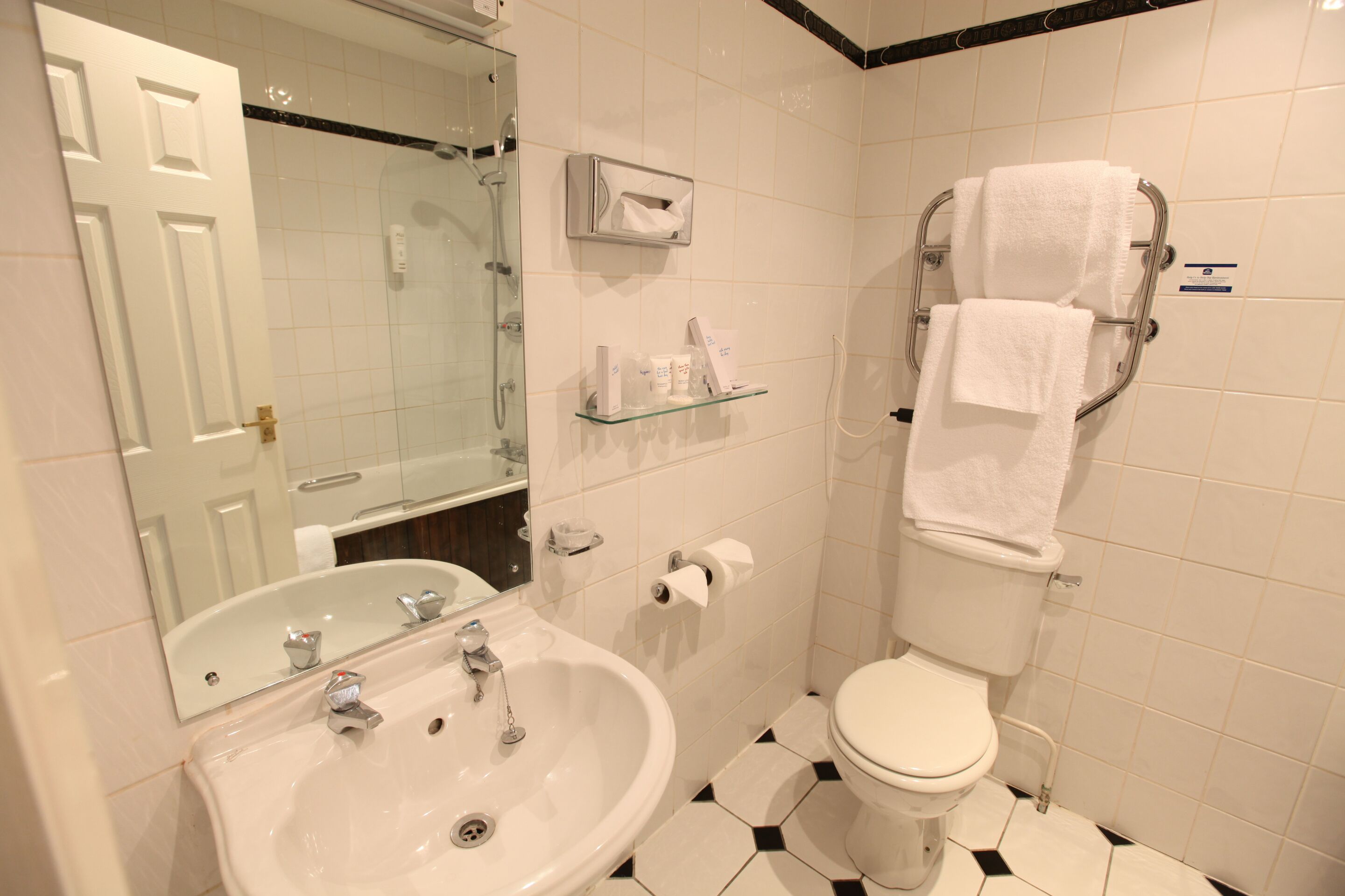 Un baño con lavamanos, inodoro y cabina de ducha de vidrio.