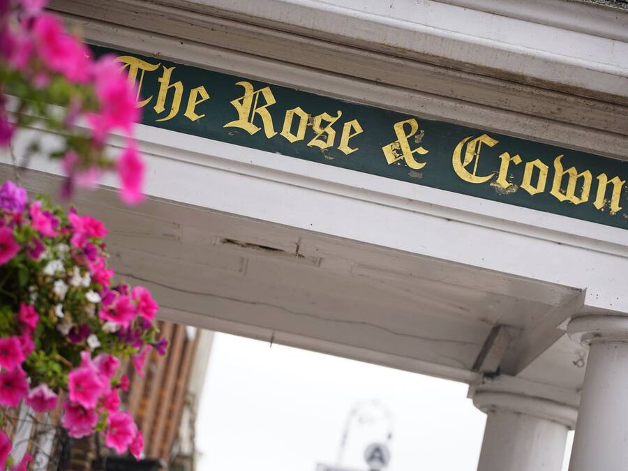 Un letrero con el texto "The Rose & Crown" en la fachada de un edificio.