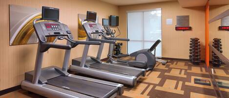 A fitness center with treadmills, a stationary bike, and a weight bench area.