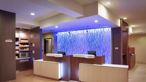 A reception area with a modern design, featuring a reception desk, a microwave, and a small kitchenette.