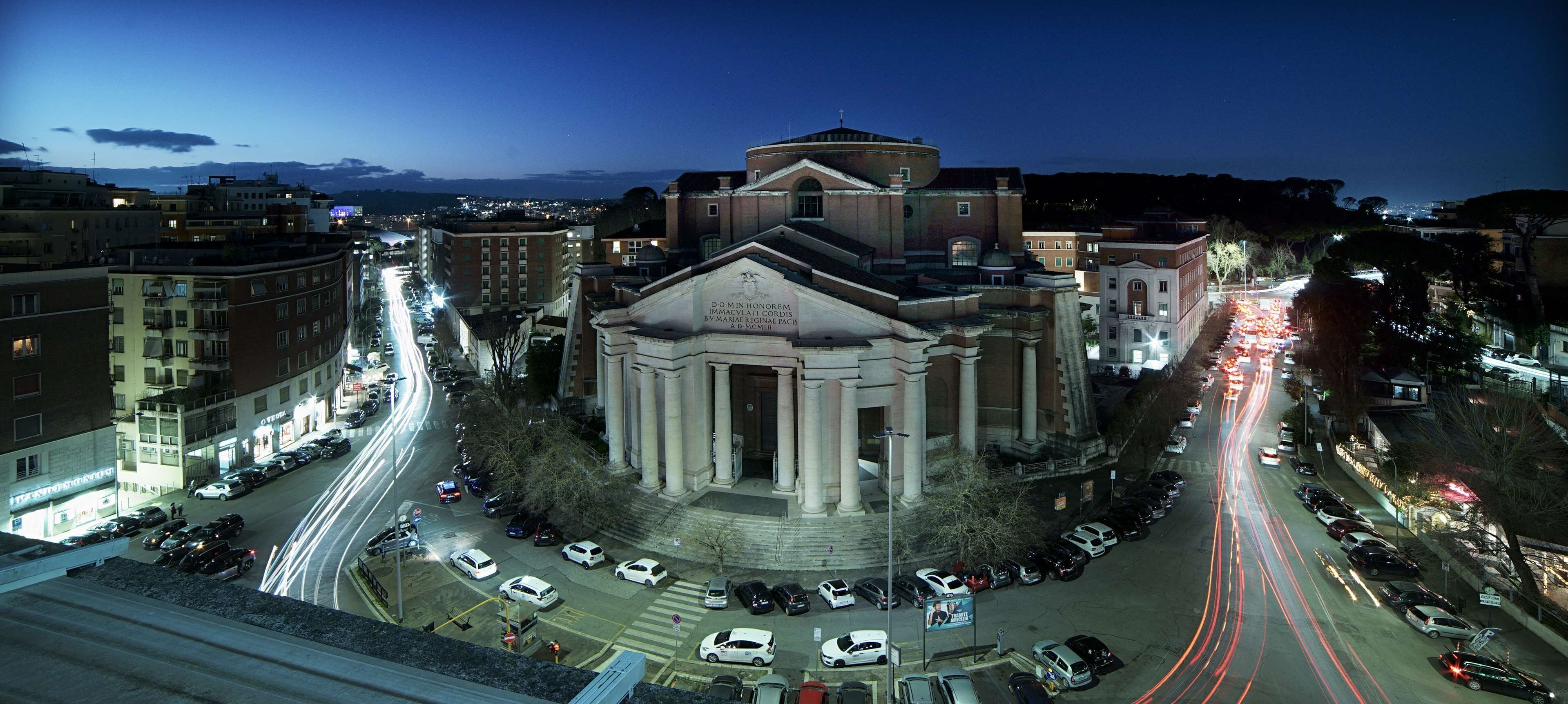 A historic building with classical architecture, surrounded by a busy urban street at night.