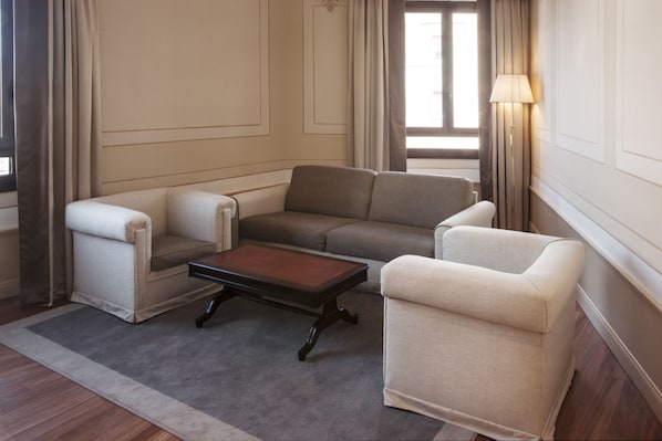 A modern living room with a sectional sofa, two armchairs, and a coffee table.