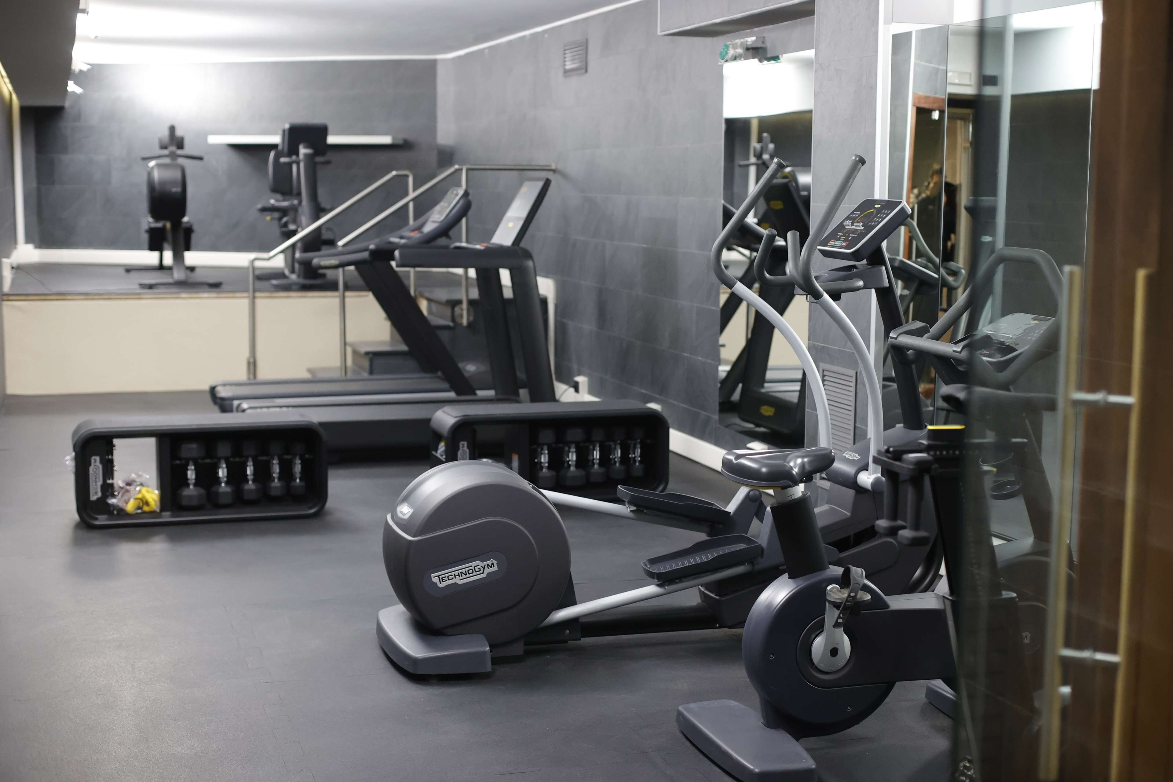 A gym with treadmills, elliptical machines, and weight machines.