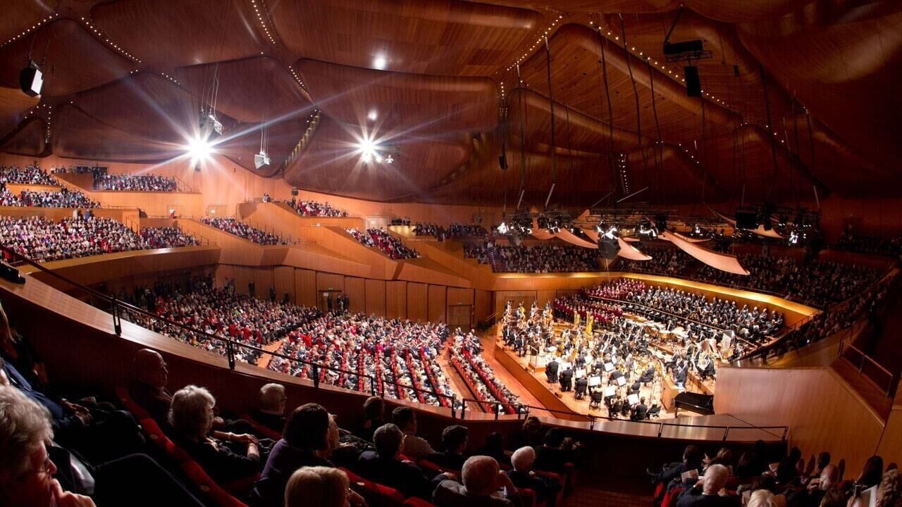 A large, multi-tiered auditorium with tiered seating and a central stage.