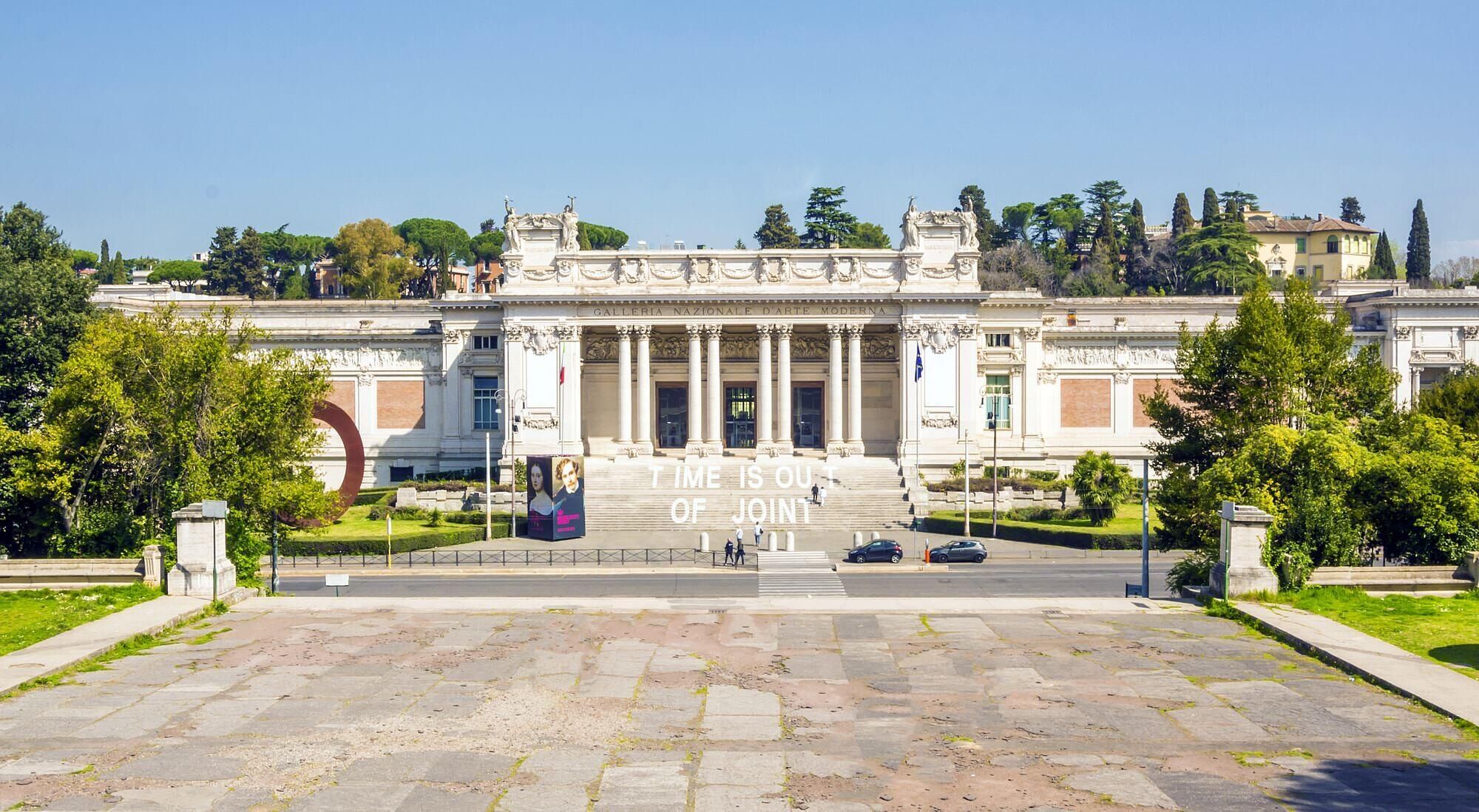 A grand building with classical architecture, featuring a central staircase leading to an entrance.