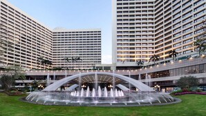 Een hotel met een centrale fontein, meerdere verdiepingen en een modern architectuur.