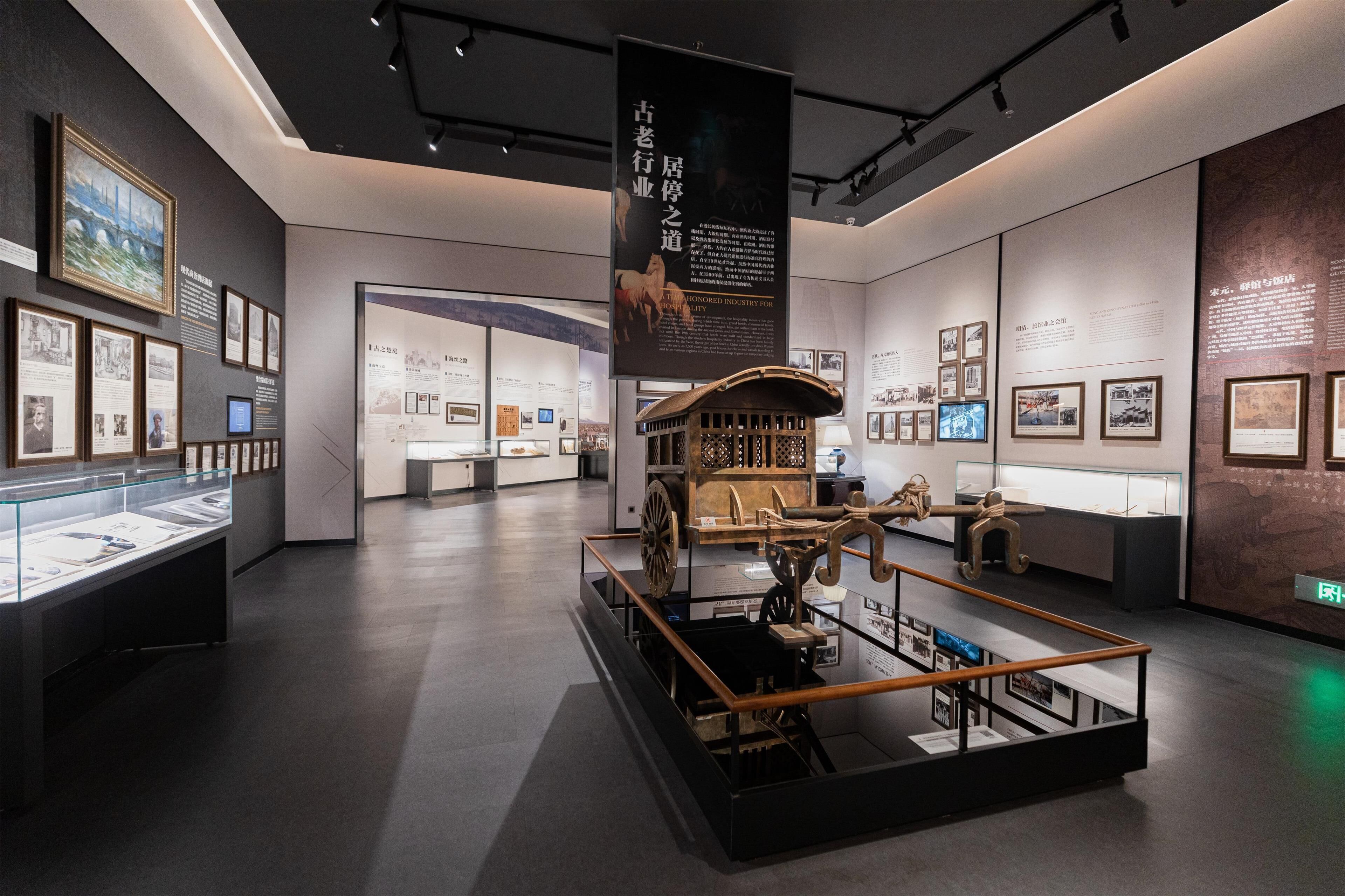 Un espace d’exposition intérieur comprenant des vitrines, des panneaux d’information et une exposition centrale présentant un objet historique.