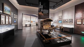 Un espace d’exposition intérieur comprenant des vitrines, des panneaux d’information et une exposition centrale présentant un objet historique.
