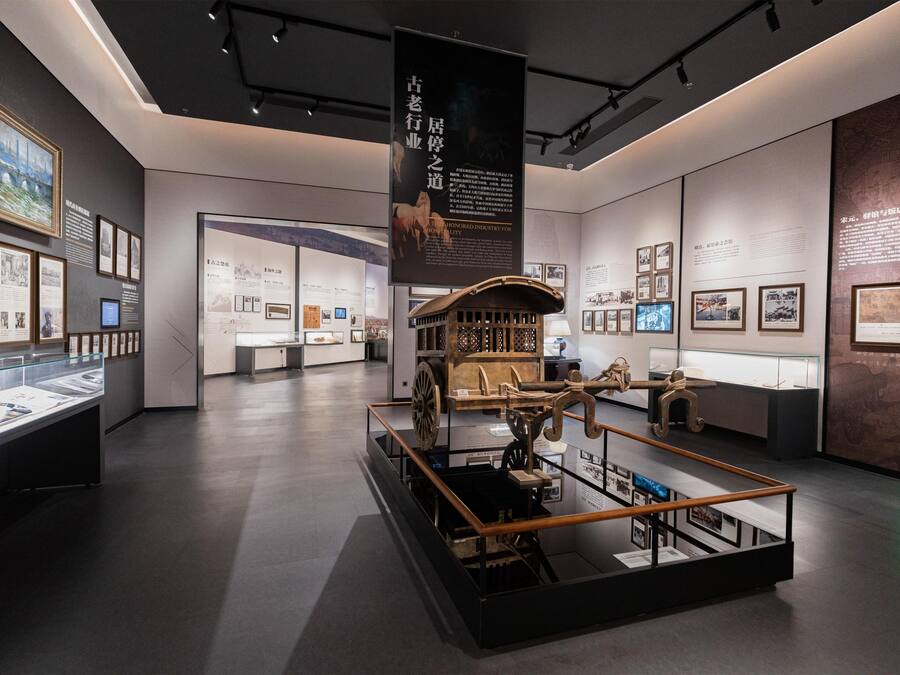 Un espace d’exposition intérieur comprenant des vitrines, des panneaux d’information et une exposition centrale présentant un objet historique.
