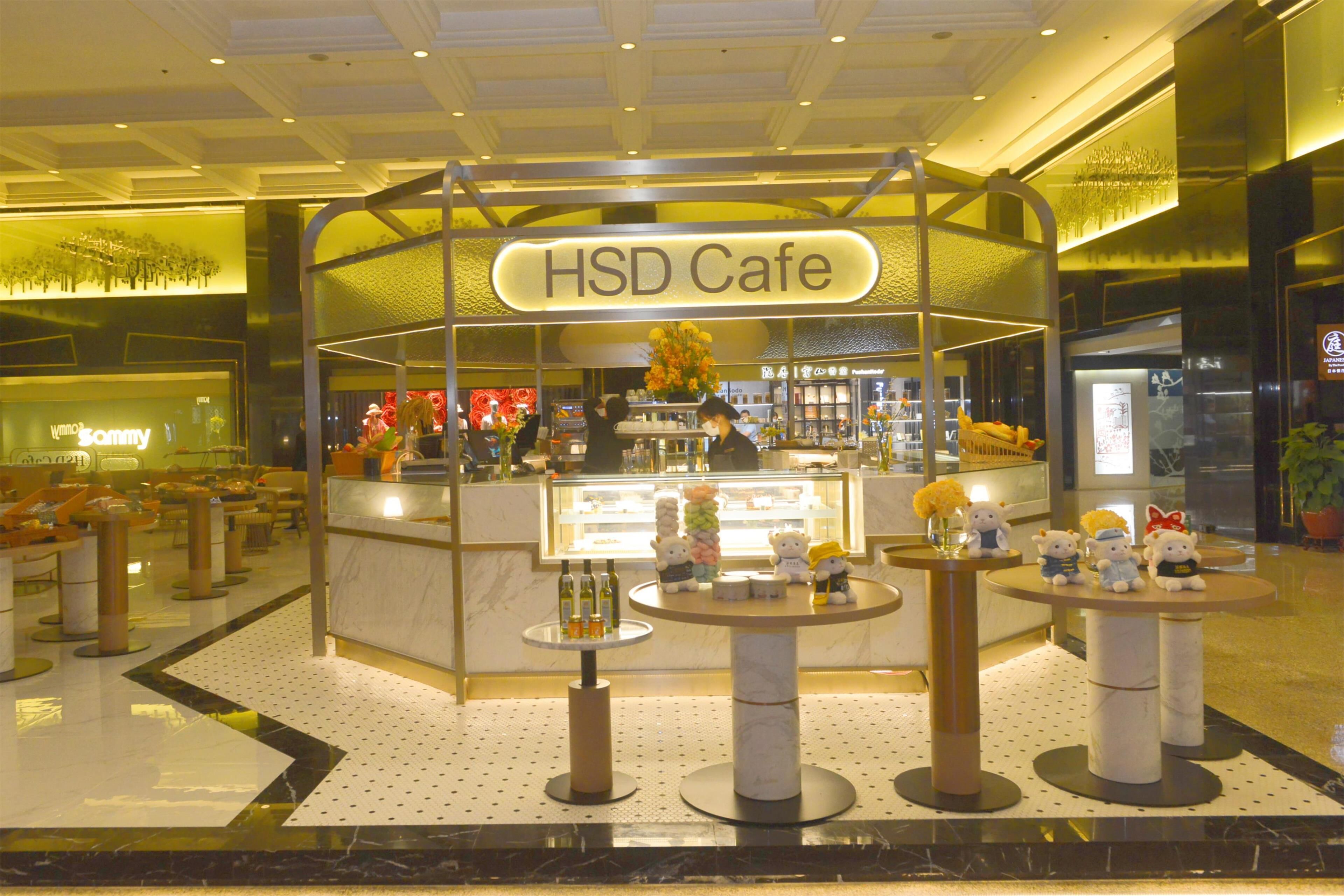 A HSD Cafe with a marble counter, small tables with decorative items, and a modern interior design.