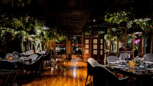 Een restaurant met houten vloeren en gedekte tafels.