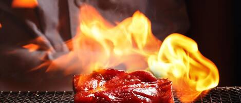A grill with meat being cooked over an open flame.