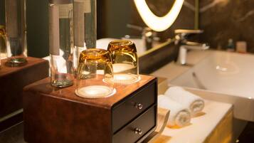 Un bagno con un mobile lavabo, uno specchio con cornice illuminata e articoli da toilette sul ripiano.