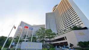 Un hotel con varios pisos, una entrada destacada y banderas.