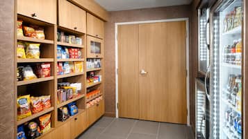 A snack and beverage area with shelves stocked with various snacks and a refrigerated section with beverages.