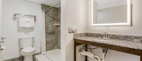 Une salle de bain moderne équipée d’une douche, de toilettes et d’un meuble-lavabo.
