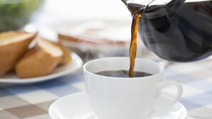 A cup of coffee being poured from a black coffee pot. - Trade Winds Inn Clinton (Clinton)