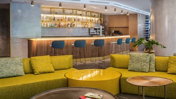 A modern bar area with a bar counter, seating, and a plant.