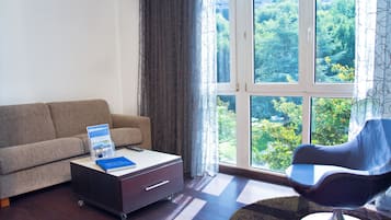 Una sala de estar moderna con un sofá, una mesa de centro con un libro, una mesita auxiliar y una silla.