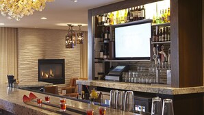 Eine Bar mit Kamin, einer Theke und Regalen voller Spirituosen.