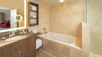 A modern bathroom with a large mirror, a bathtub, and a shower.