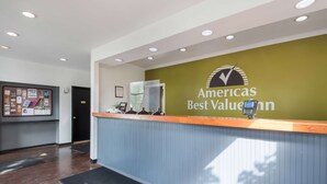 A reception area with a green wall and a wooden counter. - Americas Best Value Inn Painted Post (Painted Post)