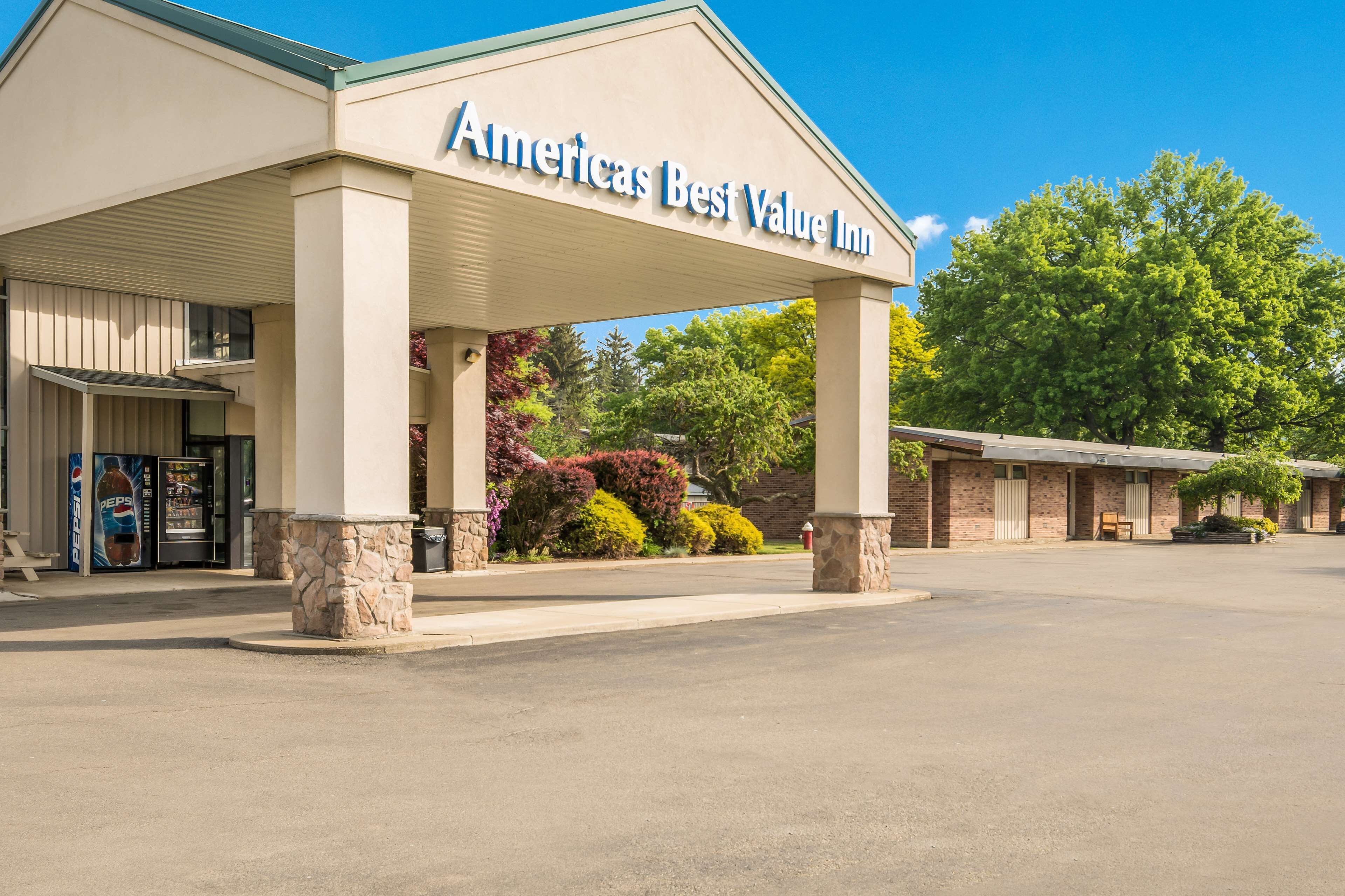 L’extérieur de l’hôtel Americas Best Value Inn se distingue par son entrée abritée, ses piliers en pierre et son parking.