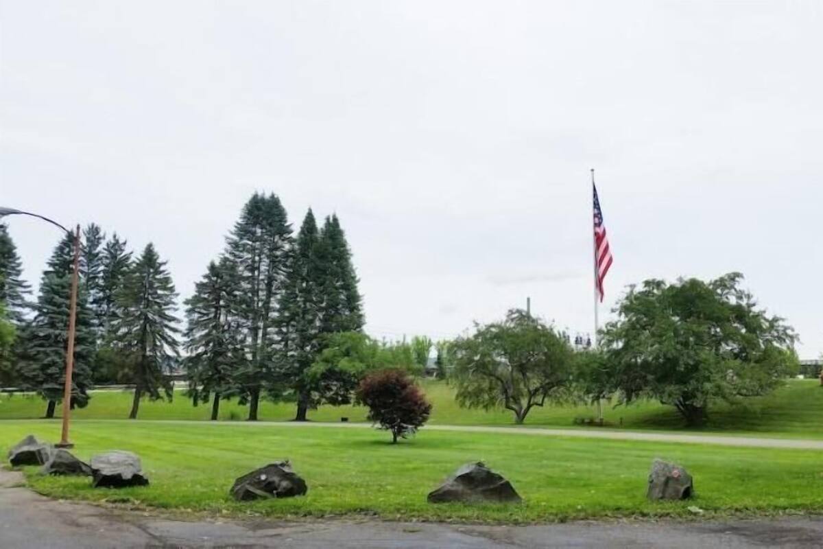 A grassy area with a flagpole and an American flag.