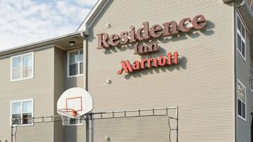 Un immeuble avec une enseigne indiquant « Residence Inn Marriott » et un terrain de basket devant.