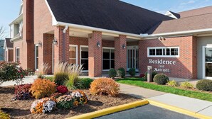 A brick building with a "Residence Inn Marriott" sign, a covered entrance, and landscaped flower beds. - Residence Inn By Marriott Peoria (Peoria)