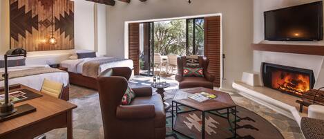 A cozy living room with a fireplace, a large TV, and a comfortable seating area.