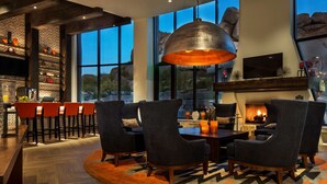 A modern interior with a bar area, seating, and a fireplace. - Boulders Resort & Spa Scottsdale, Curio Collection by Hilton (Scottsdale)
