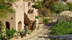 A desert-style building with arched doorways, a staircase, and a paved pathway surrounded by cacti and rocks. - Boulders Resort & Spa Scottsdale, Curio Collection by Hilton (Scottsdale)
