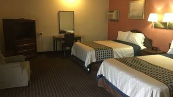 Une chambre d’hôtel avec deux lits, un bureau, une chaise, une commode et un climatiseur fixé au mur.