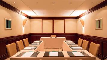 A conference room with a long table, chairs, and a podium.
