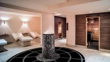 Uma área de spa moderna com cadeiras de massagem, uma fonte de mosaico central e paredes de madeira.