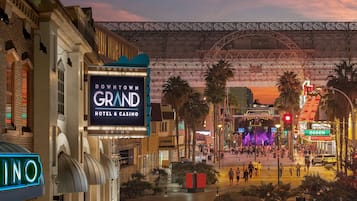 Ein im Stadtzentrum gelegenes Grand Hotel & Casino mit einer auffälligen Neonreklame, einer großen beleuchteten Anzeige und einer belebten Straßenszene.