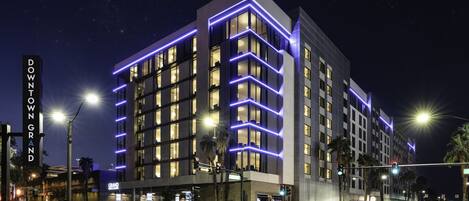 A modern hotel with a prominent sign reading "DOWNTOWN GRAND".