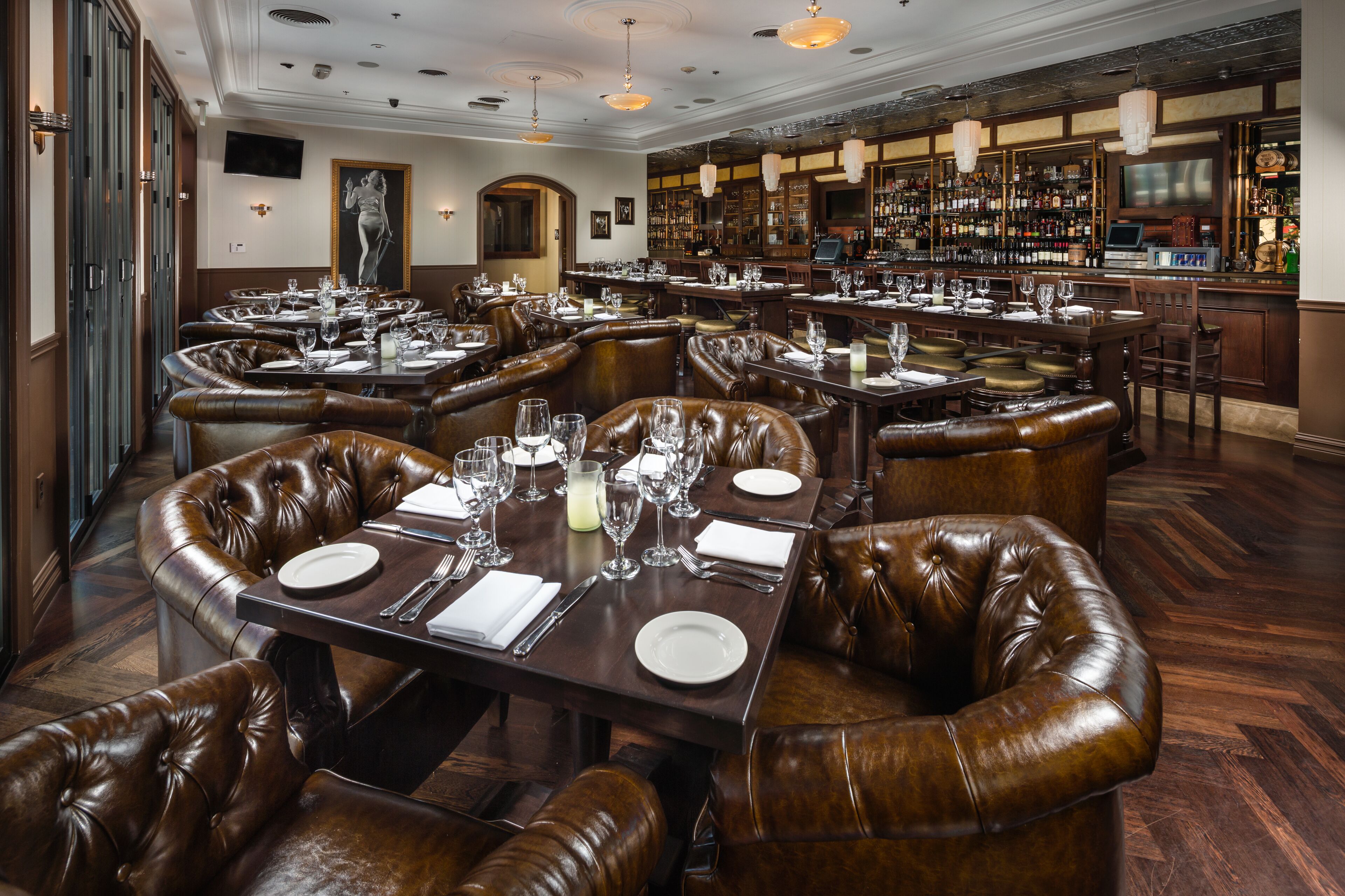 A restaurant with multiple booths and tables, each set with plates, cutlery, and glasses.