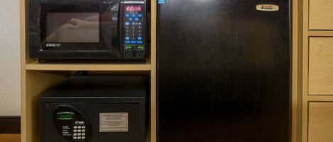 Une cuisine équipée d’un four à micro-ondes, d’un réfrigérateur et d’un coffre-fort.