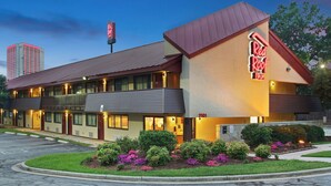 A Red Roof Inn with a two-story structure, a parking lot, and a landscaped garden with flowers. - Red Roof Inn Greensboro Coliseum (Greensboro)