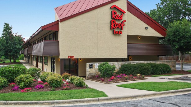 A two-story building with a red roof and beige walls, featuring a sign that reads 'Red Roof Inn.' - Red Roof Inn Greensboro Coliseum (Greensboro)