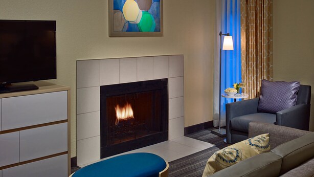 Una sala de estar moderna con chimenea, televisor de pantalla plana, sofá y comedor con mesa y sillas.