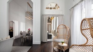 A modern interior with a dining area, a wicker chair, and a staircase.