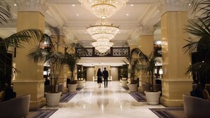 A grand lobby with a large chandelier, marble flooring, and potted plants. - The US Grant, a Luxury Collection Hotel, San Diego (San Diego)