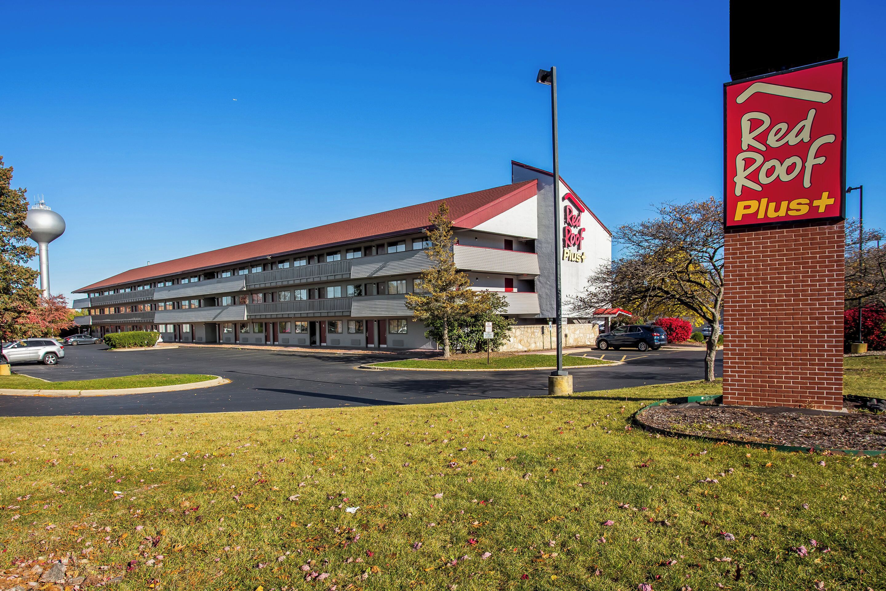 A Red Roof Plus hotel with a modern design, featuring a prominent red roof and a brick facade.