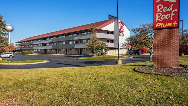 A Red Roof Plus hotel with a modern design, featuring a prominent red roof and a brick facade. - Red Roof Inn PLUS+ Chicago - Hoffman Estates (Hoffman Estates)