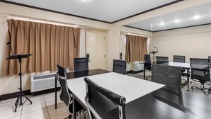 A conference room with a large table, chairs, a standing lamp, and an air conditioning unit. - Red Roof Inn PLUS+ Chicago - Hoffman Estates (Hoffman Estates)