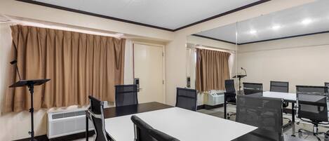 A conference room with a large table, chairs, a standing lamp, and an air conditioning unit.